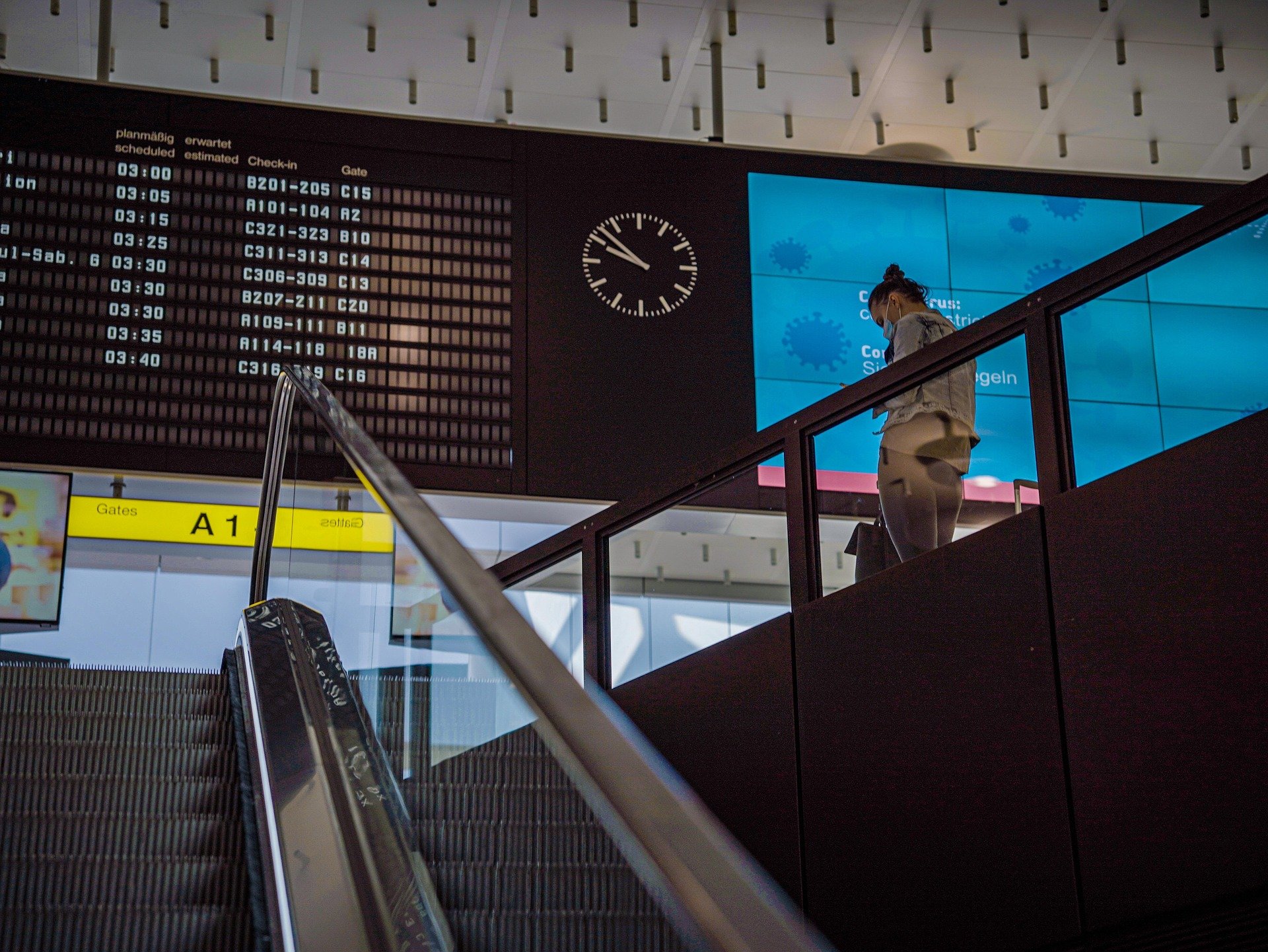 Pasajera revisando los paneles de vuelos en el aeropuerto